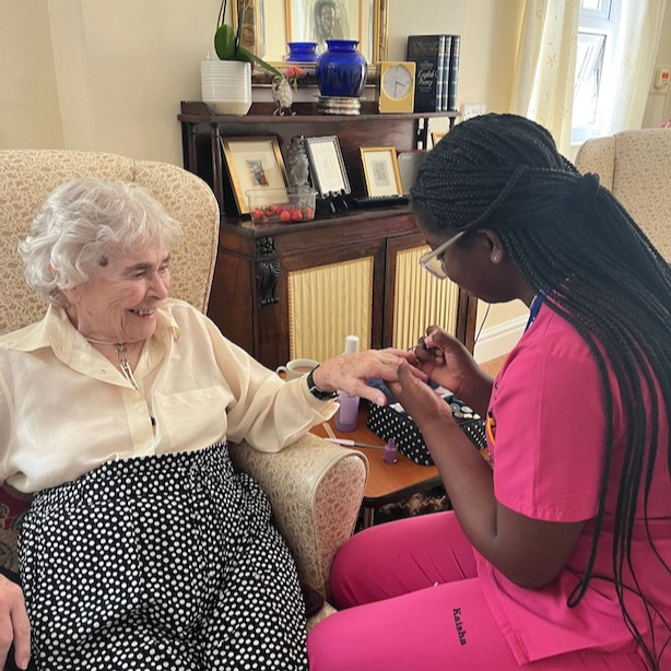 Staff member giving a resident a manicure 