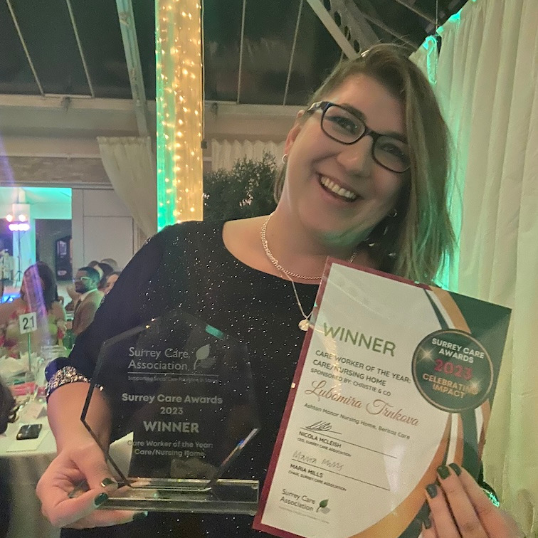 Saff member holding an award and certificate from the Surrey Care Awards
