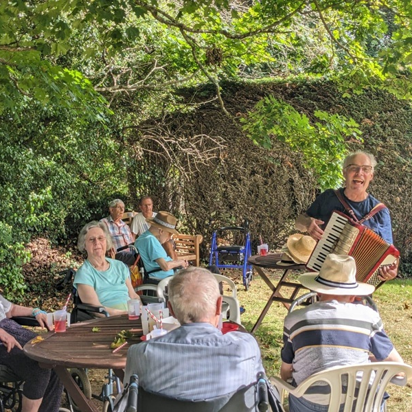 Residents sat in the garden enjoying a musical performance