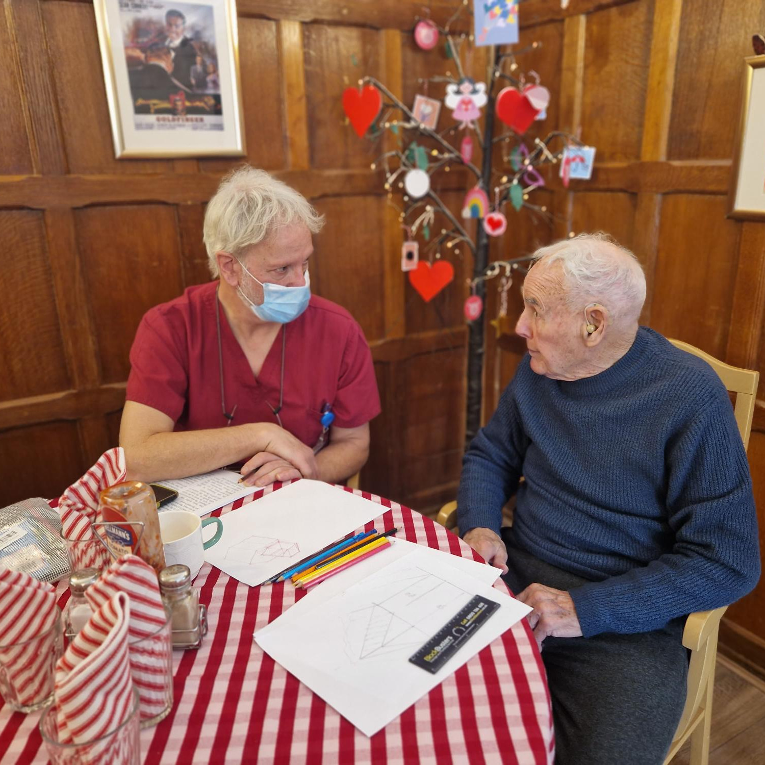 Staff member sat at a table with a resident having a chat