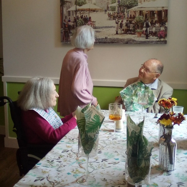 Residents in the dining room getting ready for dinner