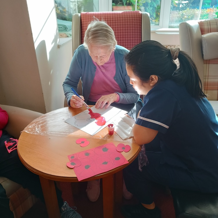Resident and staff member working on an artistic project together