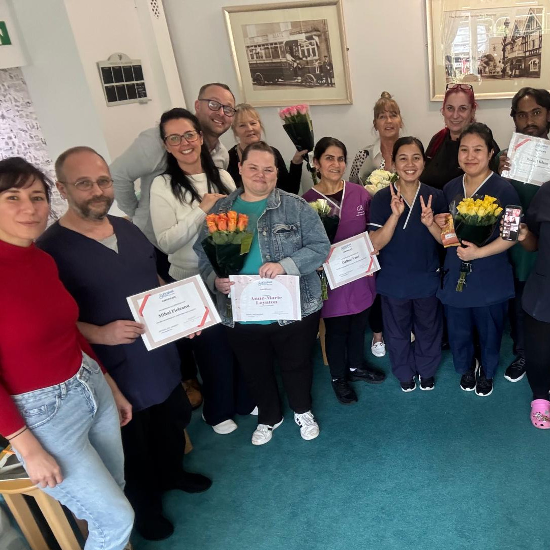 The springkell team at their staff meeting holding certificates and prizes 