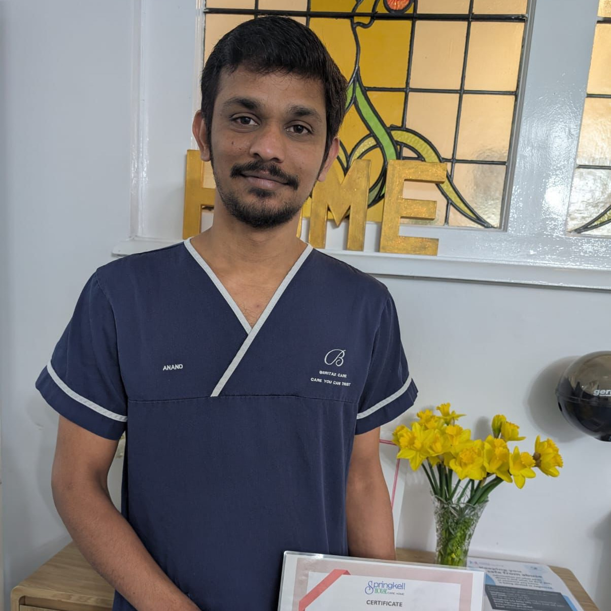 Team member holding a certificate and flowers