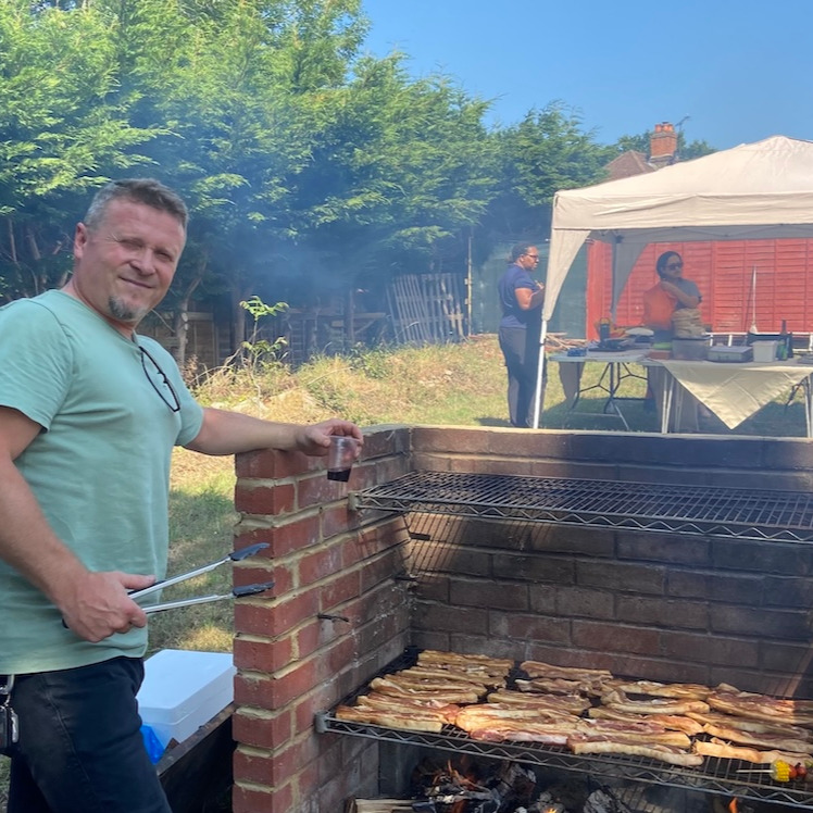 Staff member cooking food on a barbecue