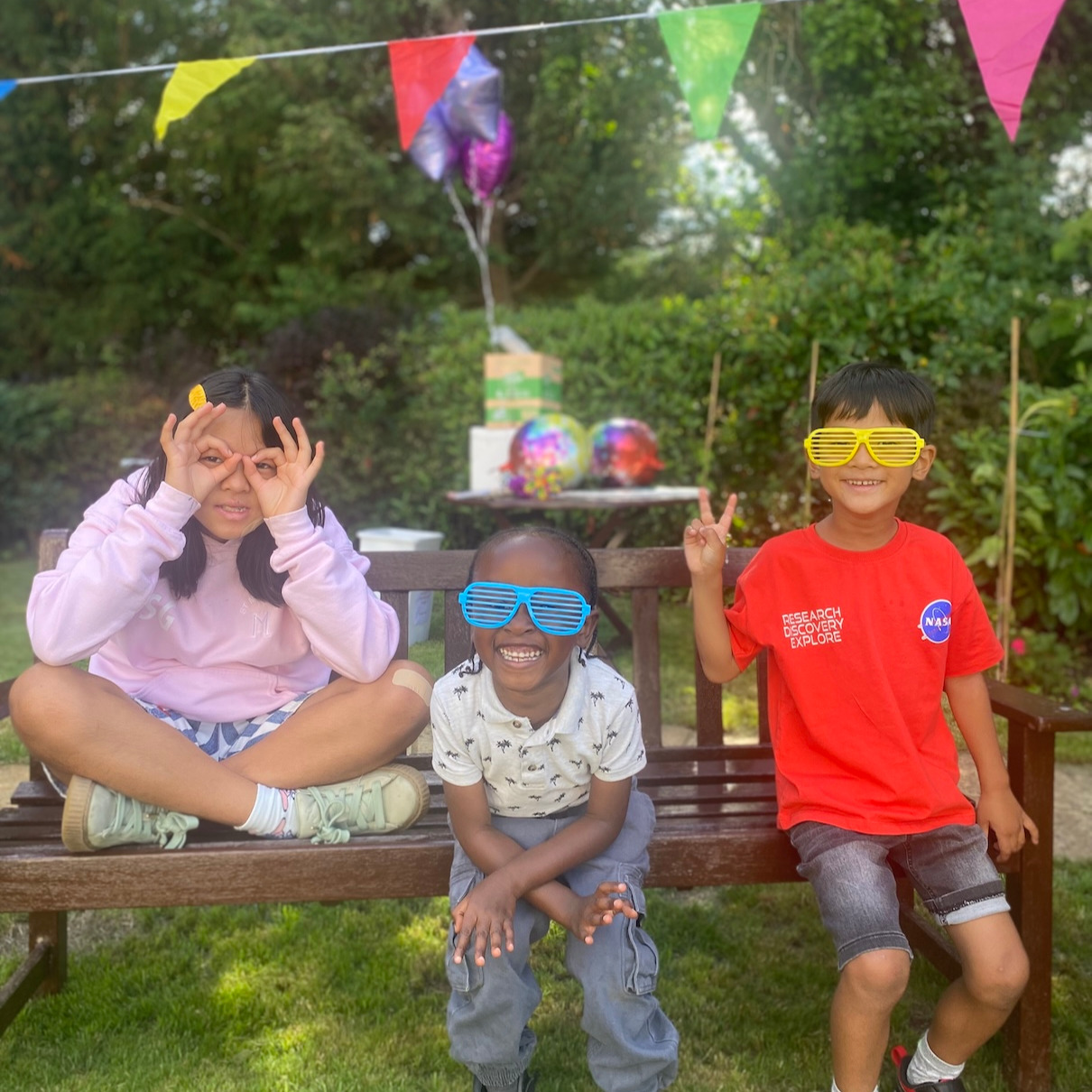 Children pulling faces and having fun at a garden party
