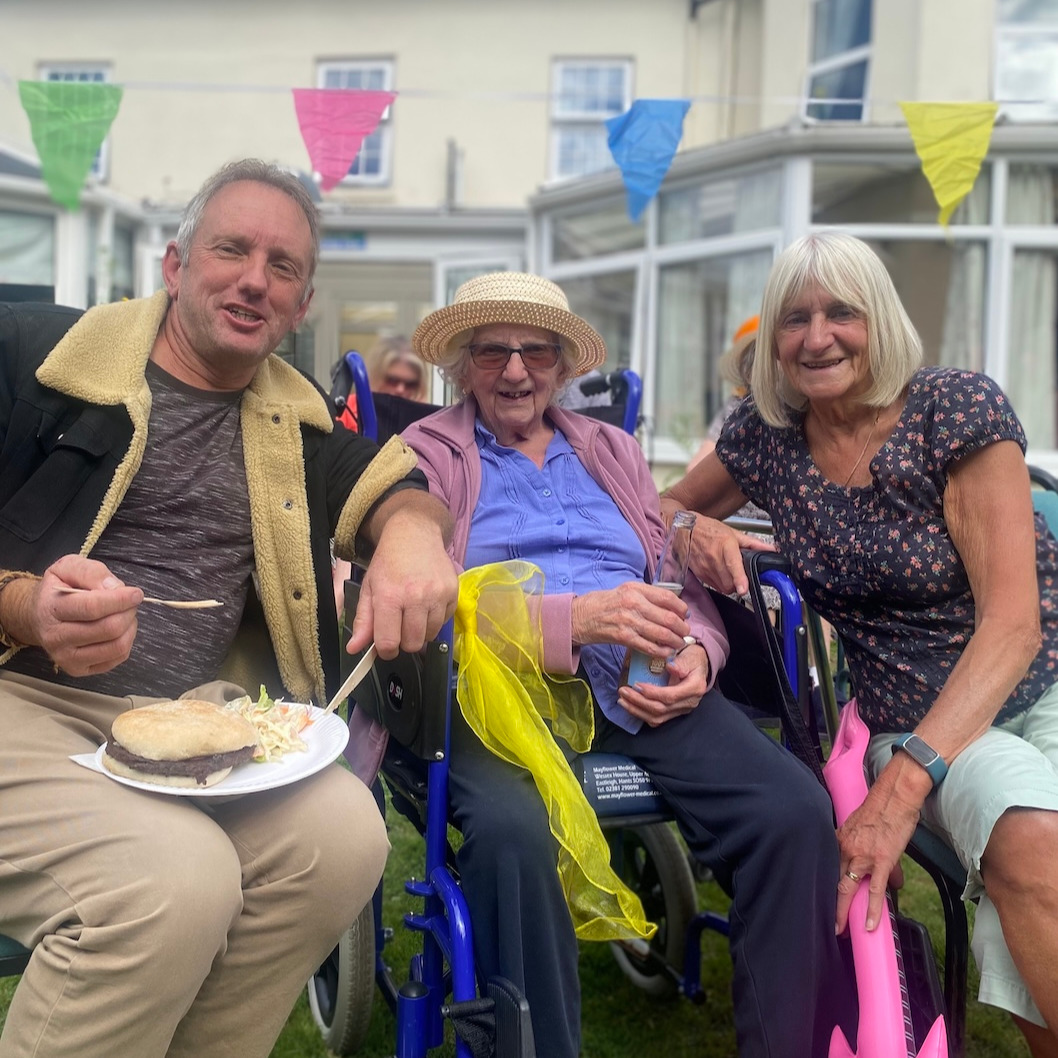 A family sat enjoying refreshments at a garden party