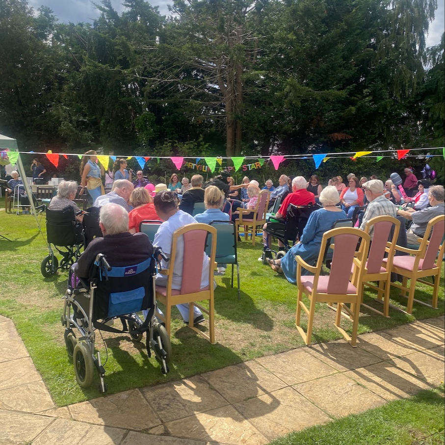 People sat on chairs watching musical entertainment outdoors