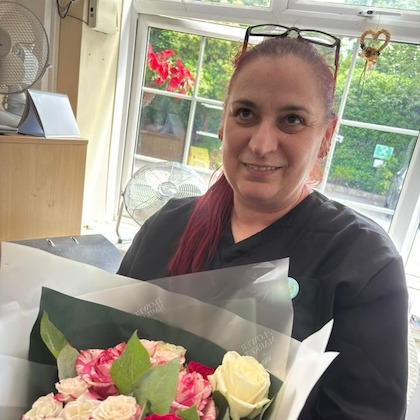 Staff member holding a bunch of flowers 