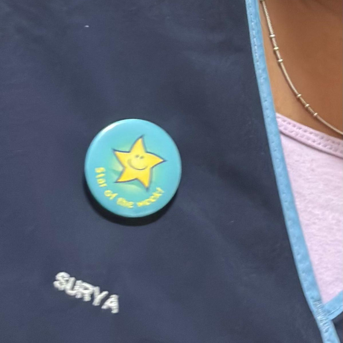 Staff member wearing 'star of the week' badge