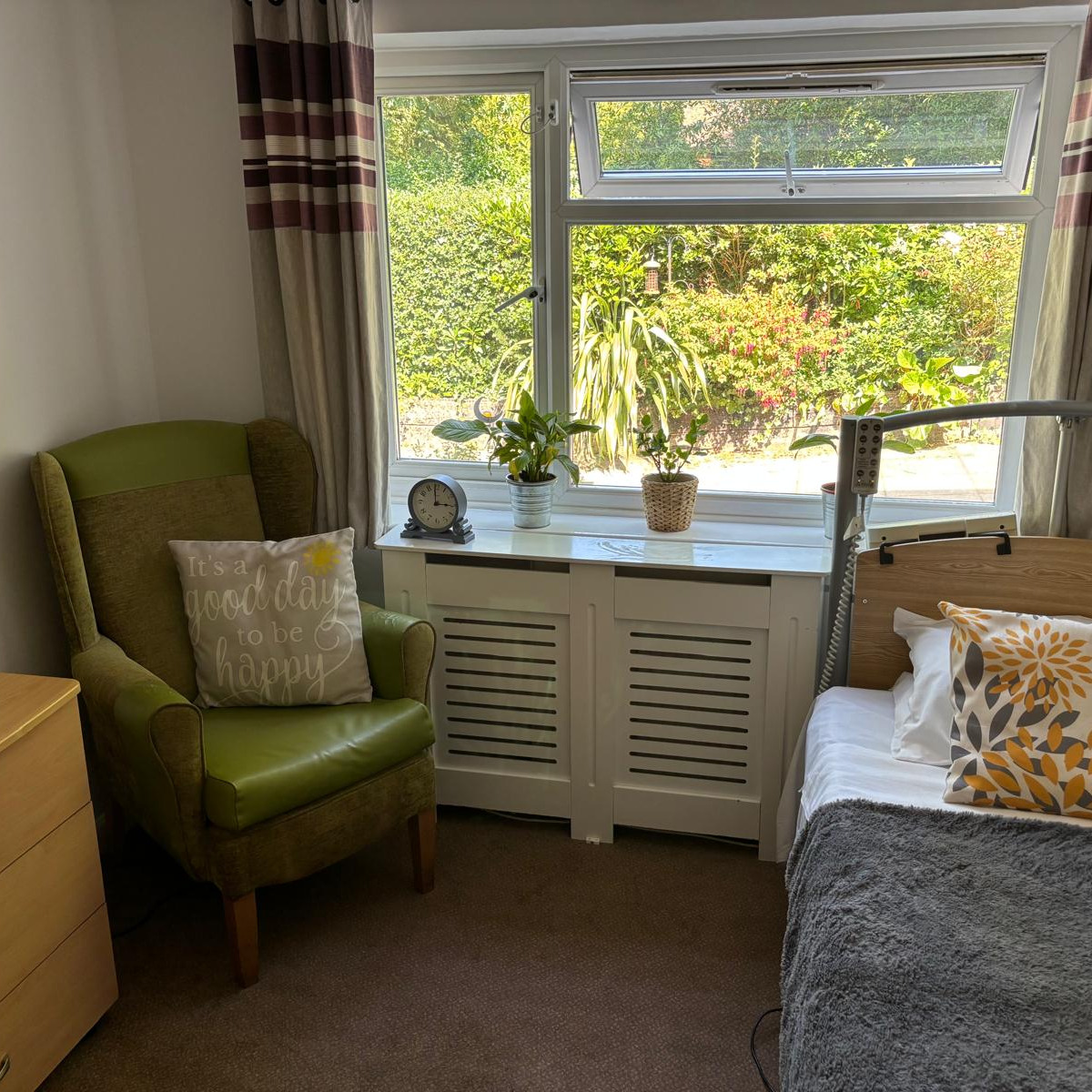 A sunlit bedroom, with bed, furniture and large window