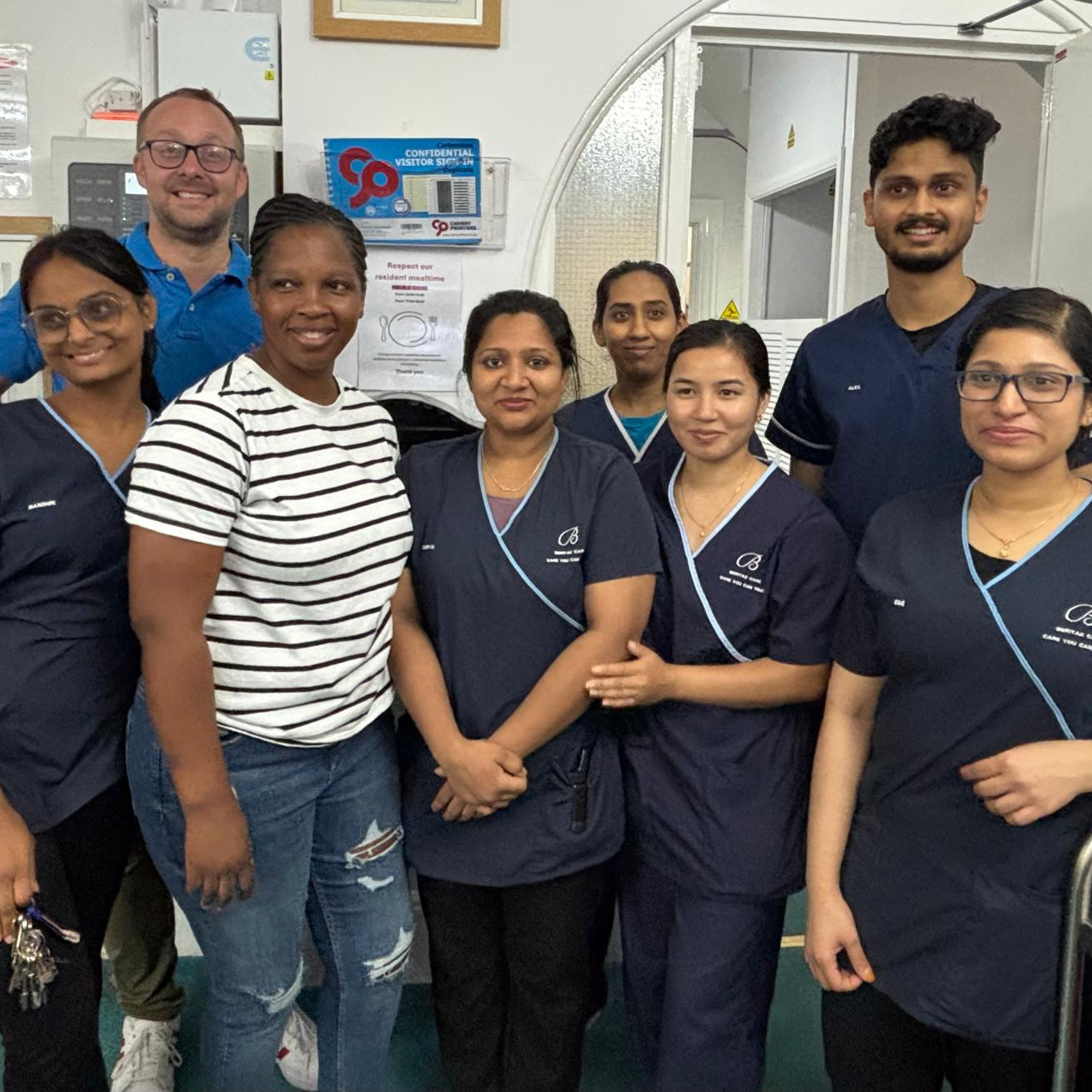 A group of care staff smiling in a care home