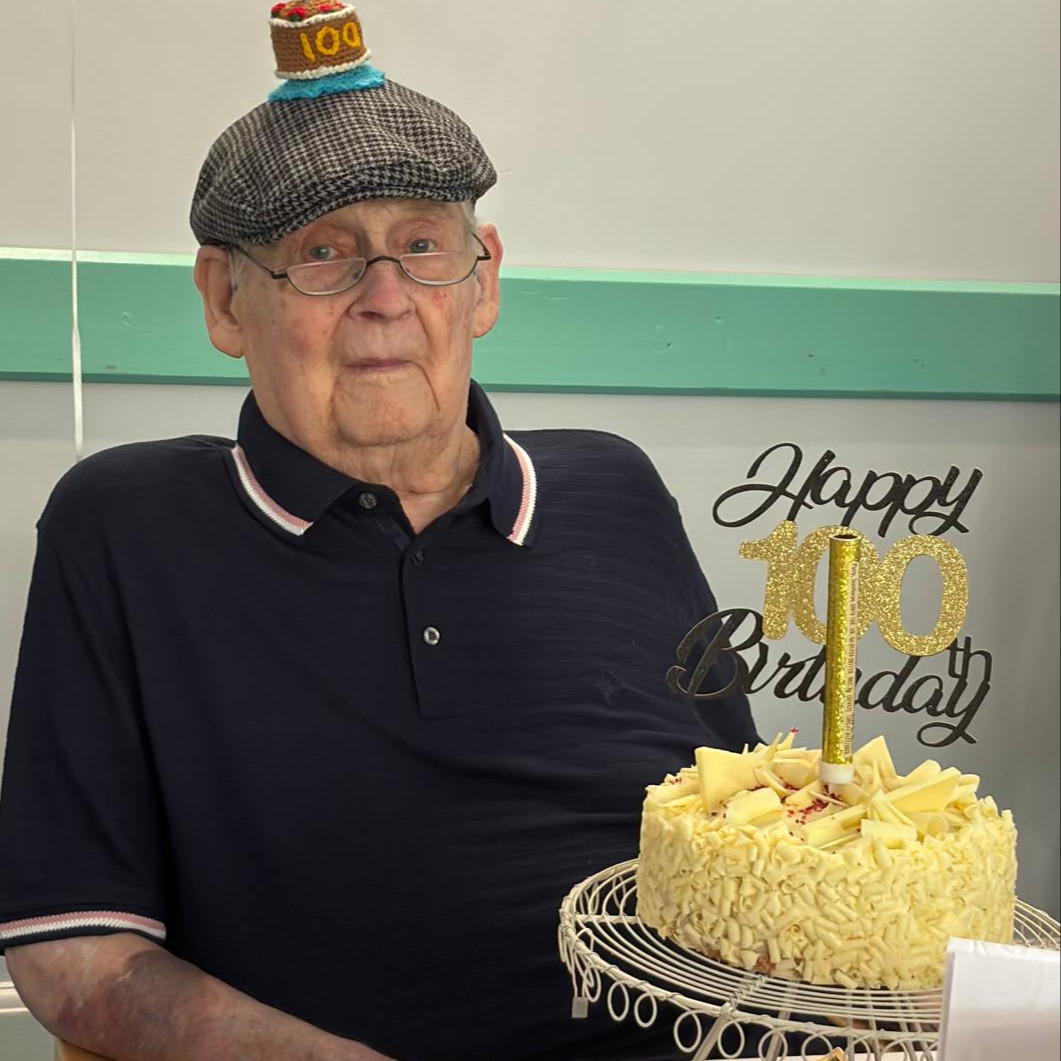 An elderly man with a birthday cake celebrating his 100th birthday 