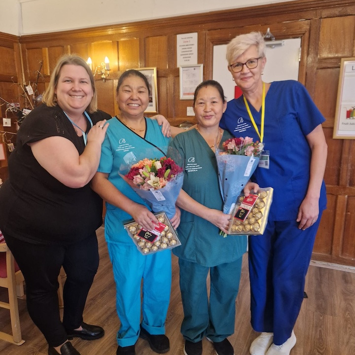 People in uniforms holding flower bouquets and gifts
