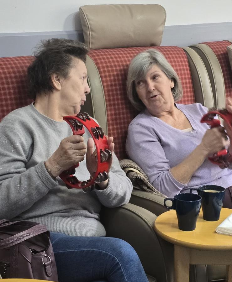 Two ladies holding musical instruments