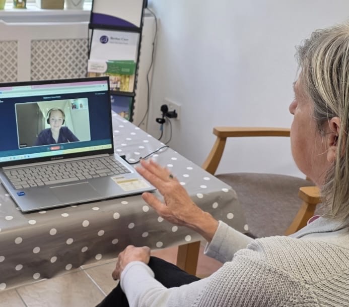 An older woman on a video call on a laptop with a younger female