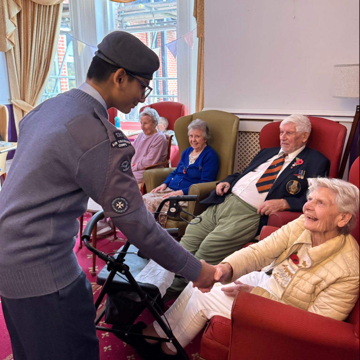 A cadet shaking hands with an older lady