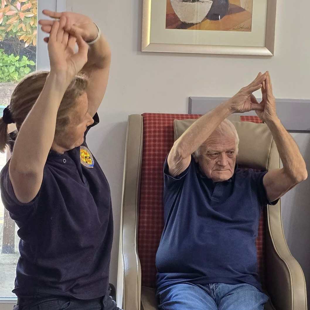 A physiotherapist helping a gentleman with exercises
