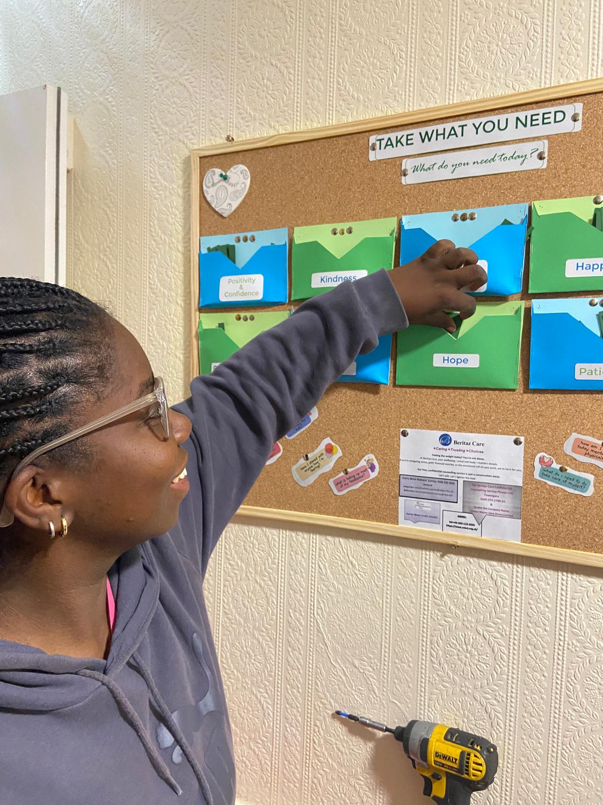 A woman taking a note from a notice board