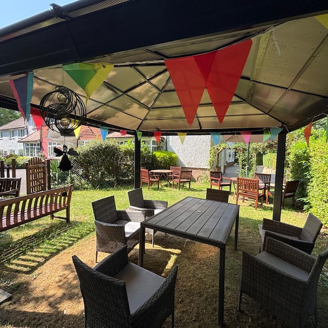 A garden gazebo with garden furniture and colourful buntng