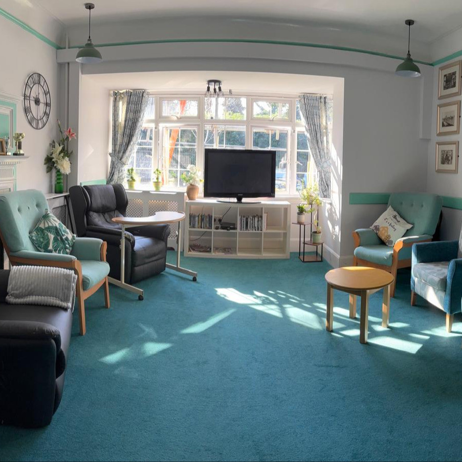 A large and bright lounge with comfortable chairs and a television