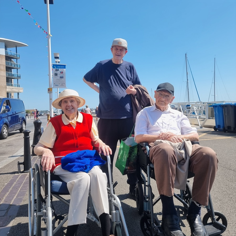 People sat in wheelchairs by the quay