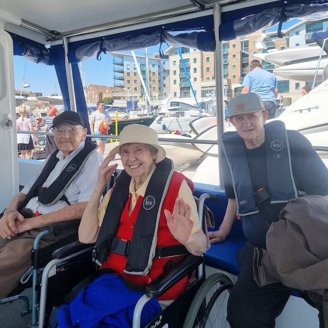 People in lifejackets sat on a boat 