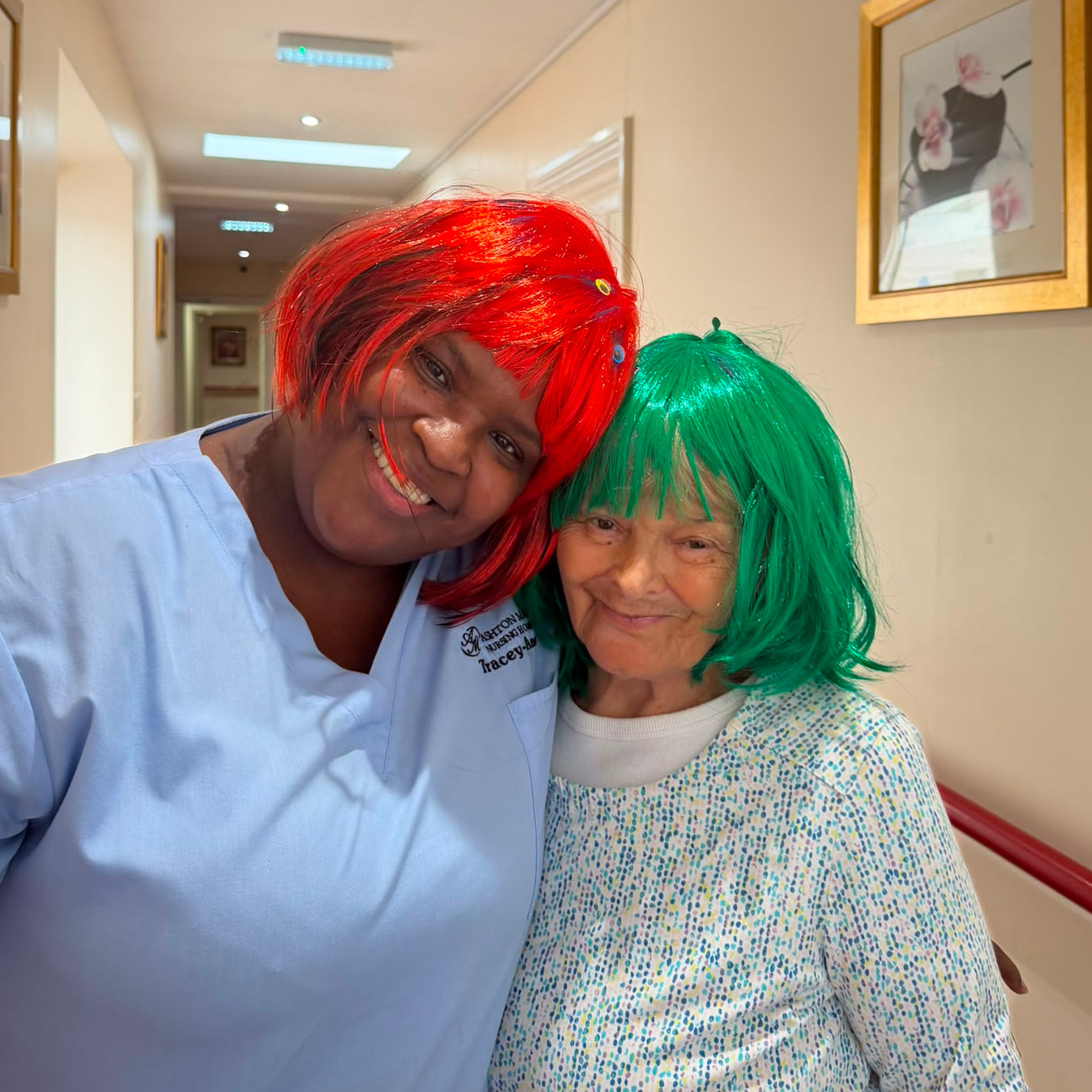 Two people wearing colourful wigs