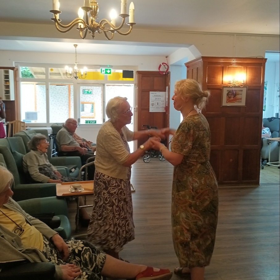 An older lady and entertainer dancing together