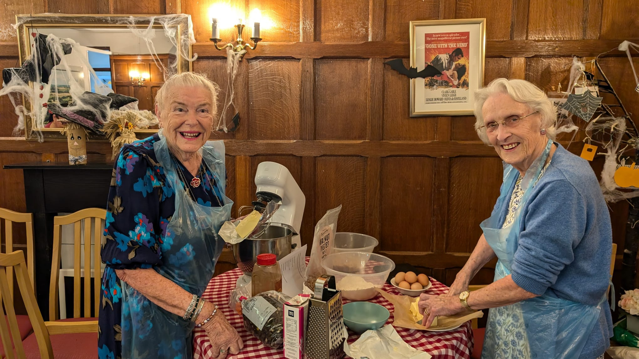 Two women stood in front of a mixer making cakes