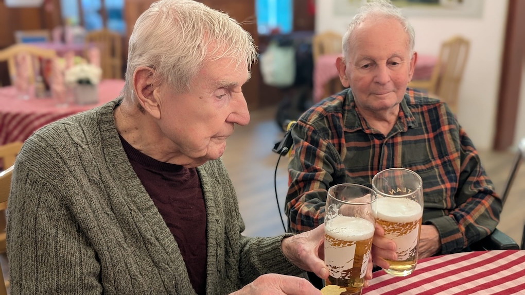 Two elderly gentleman enjoying a beer together