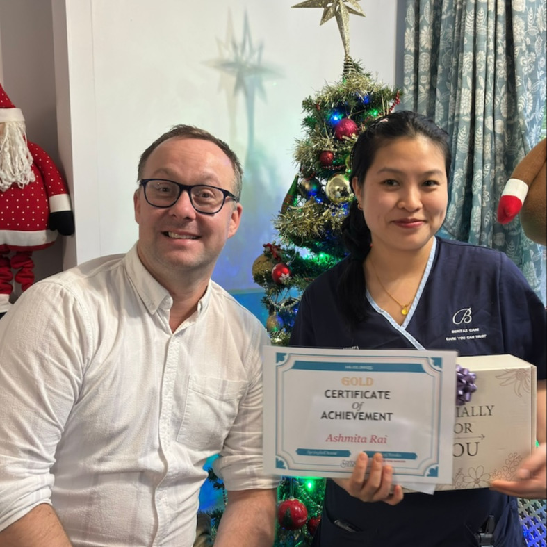 Springkell staff member being presented with an award by the home manager