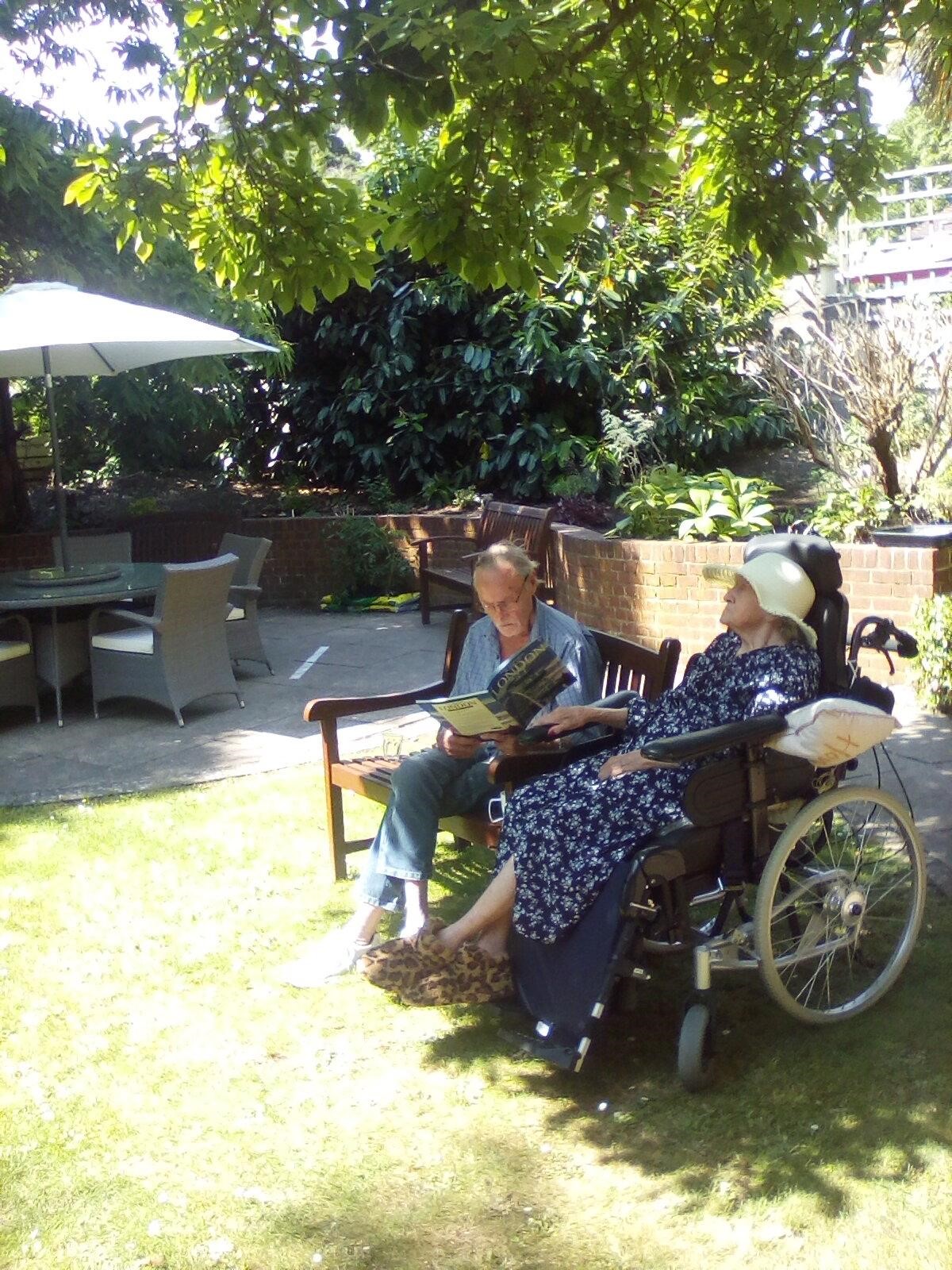 A woman in a wheelchair enjoying the sun in a clean garden