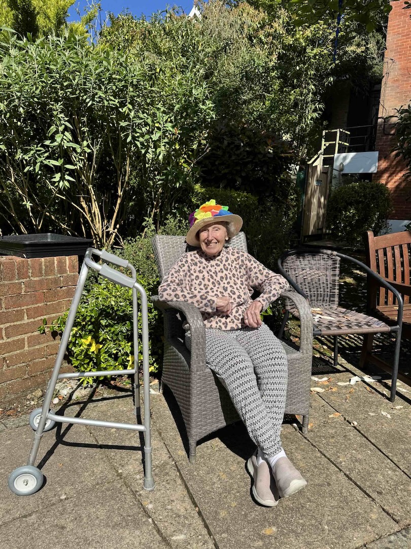 A woman sat in a chair enjoying the sun in the garden