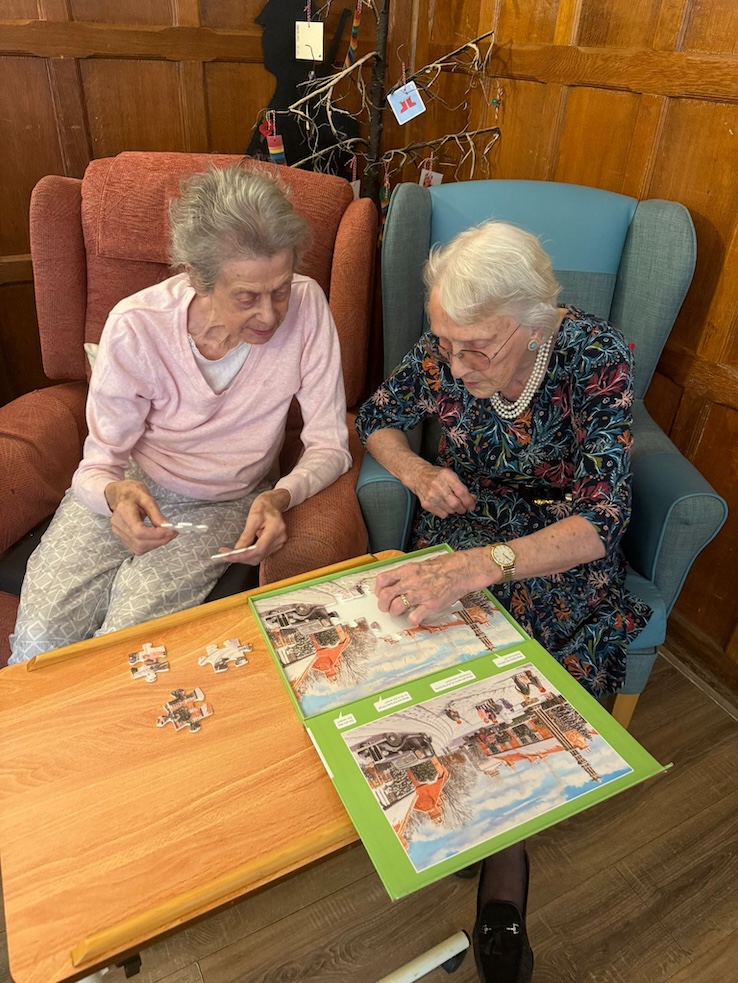 Two older women doing a jigsaw puzzle